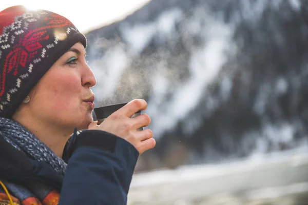 stock image Beautiful Caucasian girl is holding a cup of tea outdoors, winter time