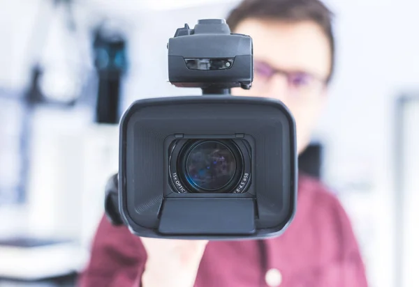 Masculino Cameraman Está Segurando Uma Filmadora Vídeo Profissional Fundo Embaçado — Fotografia de Stock