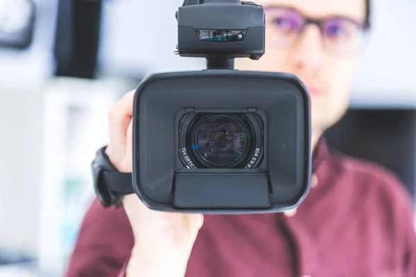 Masculino Cameraman Está Segurando Uma Filmadora Vídeo Profissional Fundo Embaçado — Fotografia de Stock