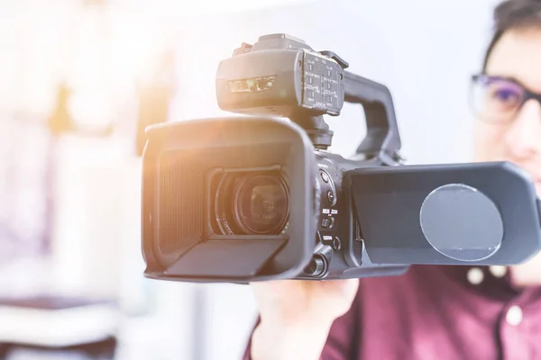 Masculino Cameraman Está Segurando Uma Filmadora Vídeo Profissional Fundo Embaçado — Fotografia de Stock