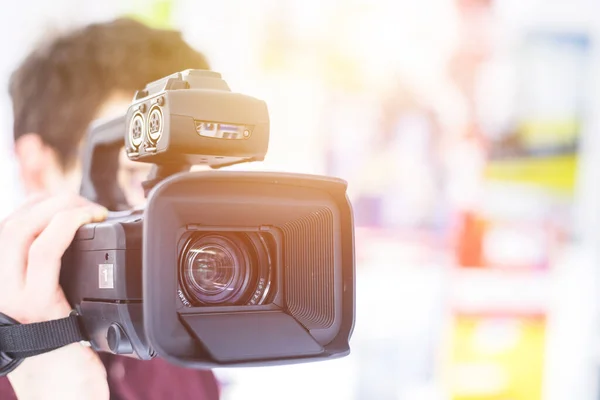 Masculino Cameraman Está Segurando Uma Filmadora Vídeo Profissional Fundo Embaçado — Fotografia de Stock