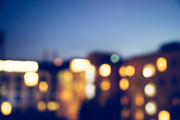 Blurry apartment block at dusk, urban city life, lights
