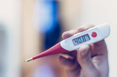 Adamın elinde kızıl humma termometresi var.