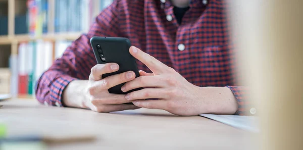 Jovem Está Segurando Telefone Celular Suas Mãos Casa Escritório — Fotografia de Stock