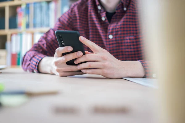 Jovem Está Segurando Telefone Celular Suas Mãos Casa Escritório — Fotografia de Stock
