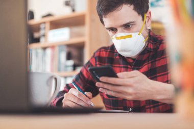 Corona krizi sırasında genç adam maske takıyor.