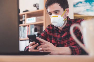 Corona krizi sırasında genç adam maske takıyor.