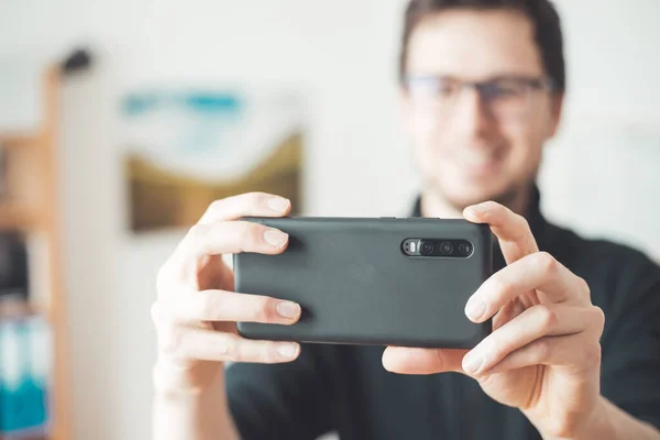 Close up of black smartphone camera, filming and making pictures indoors. Content production.