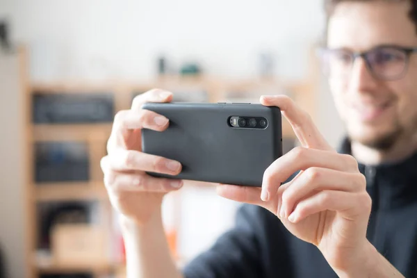 Close up of black smartphone camera, filming and making pictures indoors. Content production.