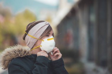 Dışarıdaki genç kadın maske takıyor. Corona virüsü ve grip mevsimi.