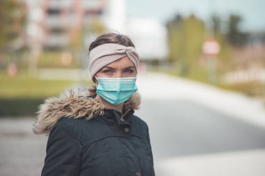 Açık havada maske takan genç bir kadın. Corona virüsü ve grip mevsimi.