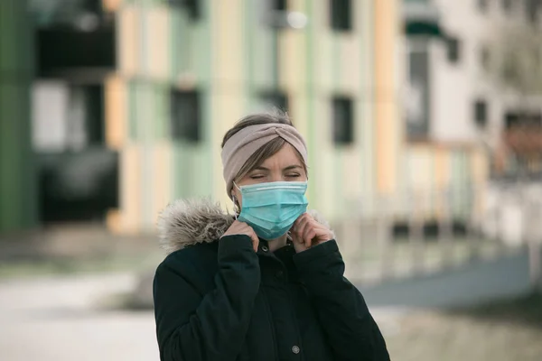 若い女性の屋外の顔のマスクを置く コロナウイルスとインフルエンザの季節 — ストック写真