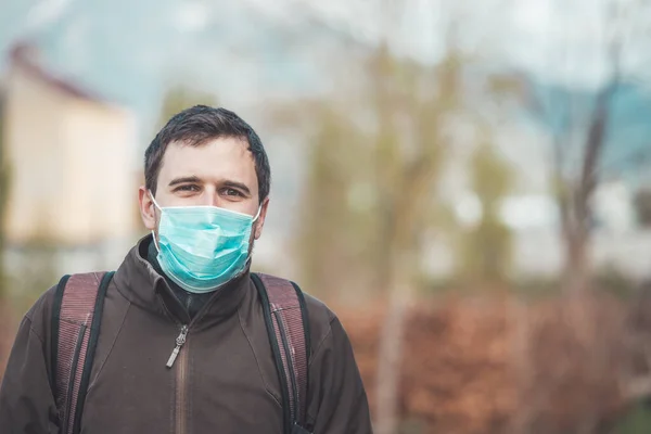 若い男は屋外でフェイスマスクを着用 コロナウイルスとインフルエンザの季節 — ストック写真