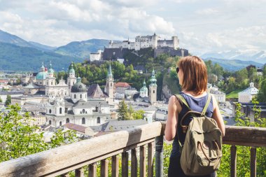 Kadın turist, Salzburg 'un tarihi bölgesinin manzarasının keyfini çıkarıyor