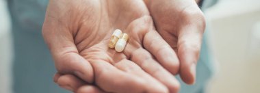Erkek eli uyuşturucu ya da vitamin hapı tutuyor
