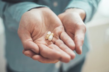 Erkek eli uyuşturucu ya da vitamin hapı tutuyor