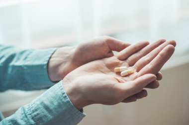 Erkek eli uyuşturucu ya da vitamin hapı tutuyor