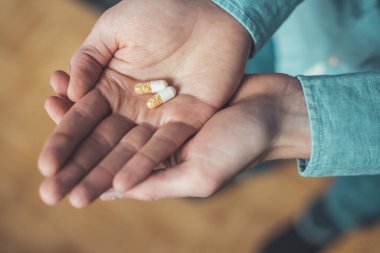 Erkek eli uyuşturucu ya da vitamin hapı tutuyor