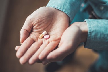 Erkek eli uyuşturucu ya da vitamin hapı tutuyor