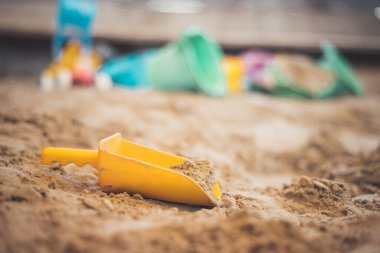 Çocuklar kum havuzunda plastik oyuncaklar. Kürek, seçici odaklanma. 