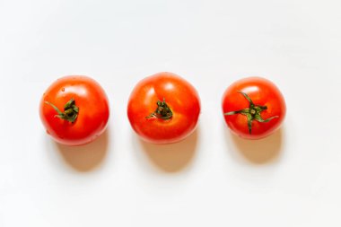 Beyaz arka planda izole edilmiş taze kırmızı domates üçlüsü - düz görünüm