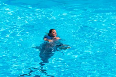 Roma, İtalya - Eylül 2019: Gösterisinin ortasında eğitmeni eşliğinde yunus