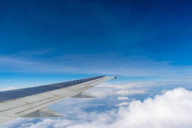 Bulutların üzerinde uçan bir uçağın kanadı 