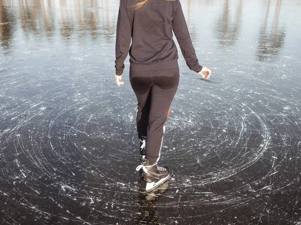 Ragazza pattinaggio su ghiaccio in pantaloni bagnati. Vista posteriore — Foto Stock