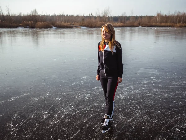 Девушка катается на коньках по льду лесного озера — стоковое фото