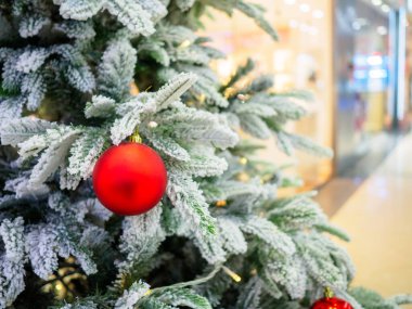 Bir alışveriş merkezinde Noel ağacı mağaza pencerelerinin arka planında
