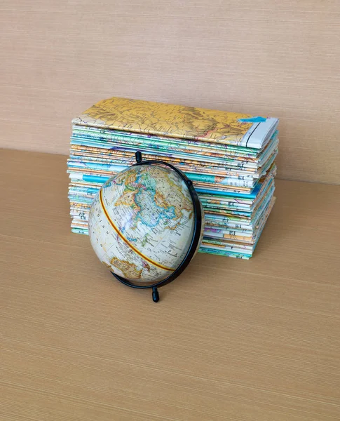 Globo e mapas sobre mesa de madeira — Fotografia de Stock
