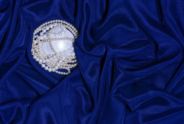Жемчужное ожерелье на драпированной ткани — стоковое фото