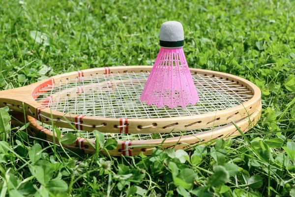 Badminton rackets and shuttlecock on grass