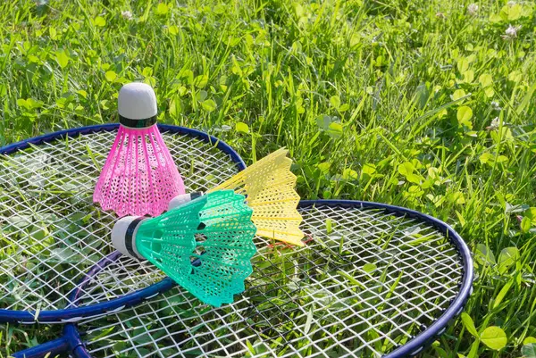 Badminton rackets and shuttlecocks on grass — Stock Photo, Image