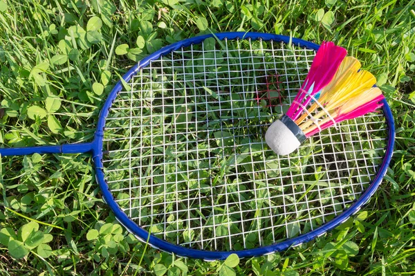 Badminton racket and shuttlecock on grass — Stock Photo, Image