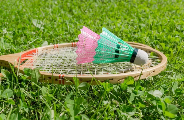 Badminton rackets and shuttlecocks on grass — Stock Photo, Image