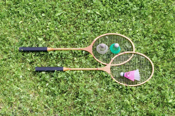 Badminton rackets and shuttlecocks on grass — Stock Photo, Image