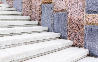 Taş duvarın yanındaki beyaz granit merdivenler. Tam çerçeve