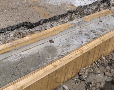 Çimento, asfalt yüzeyinin yanındaki ahşap formda. Yol onarımları