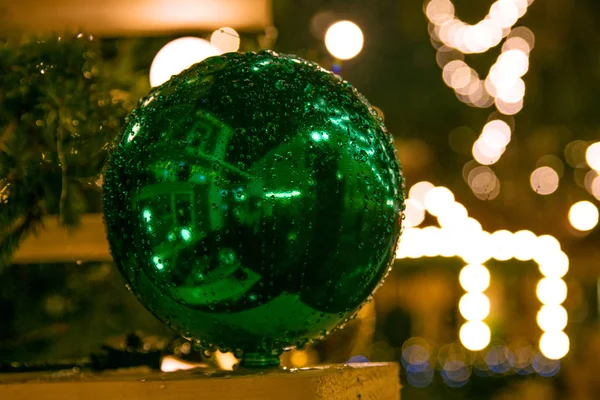 Green Christmas ball in drops from the rain against the backgrou — Stock Photo, Image