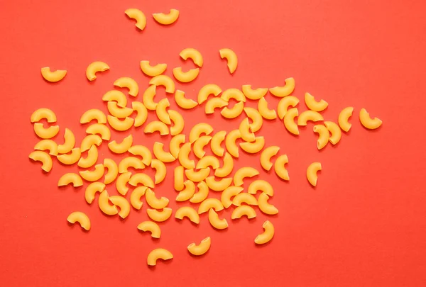 Uncooked Macaroni Lies Red Background — Stock Photo, Image
