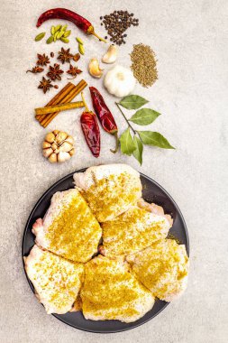 Geleneksel Hint baharatlı çiğ tavuk butları. Sarı köri karışımı, yıldız anason, kakule, defne yaprağı, biber, sarımsak, tarçın. Taş zeminde yemek pişirmek için gerekli malzemeler, üst görünüm.