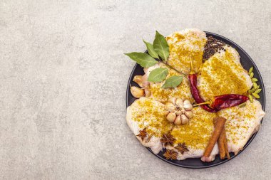 Geleneksel Hint baharatlı çiğ tavuk butları. Sarı köri karışımı, yıldız anason, kakule, defne yaprağı, biber, sarımsak, tarçın. Taş zemin üzerinde yemek pişirmek için gerekli malzemeler üst görünüm kopyalama alanını kapat.