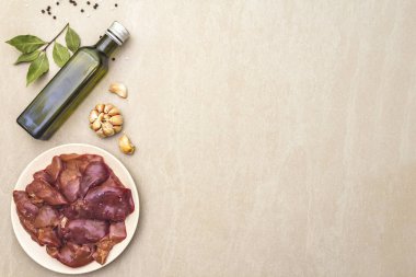 Taş zeminde baharatlı çiğ tavuk ciğeri. Sarımsak, zeytinyağı, karabiber, defne yaprağı, üst görünüm, boşluk kopyala.