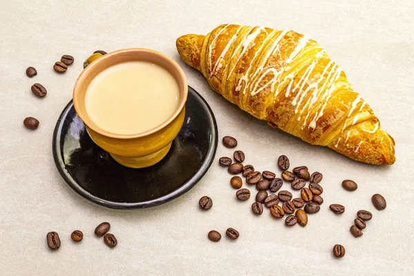 Une tasse de café frais avec croissant. Le concept sur fond de pierre, close up . — Photo