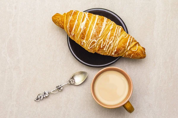 Une tasse de café frais avec croissant. Le concept sur fond de pierre avec cuillère vintage en argent, gros plan, vue de dessus . — Photo