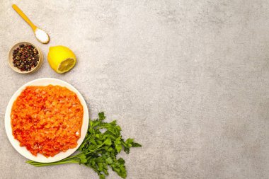 Taş bir arka planda çiğ kırmızı balık (dolma). Balık köftesi, güveç, terrine, börek yapmak için. Baharat, tuz, maydanoz, limon. Bir taş arkaplanda, üst görünümde, boşluğu kopyala.