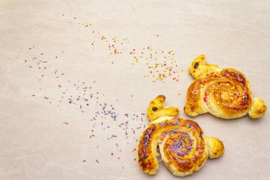 Paskalya tavşanı şeklinde taze çörek. Çocuk tatil pastanesi kavramı. Taş arkaplanda, boşluğu kopyala.