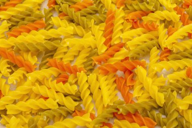 Taştan arka planda çok renkli tüyler var. Geleneksel İtalyan makarnası, çocuklar için hazırlık, üst manzara. Yemek pişirme duvar kağıdı konsepti, makro