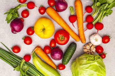 Çeşitli taze organik sebzeler. Yemek pişirme taşı arka planı. Sağlıklı vejetaryen (vegan) yeme konsepti, yakın çekim, üst görünüm, düz yatış.